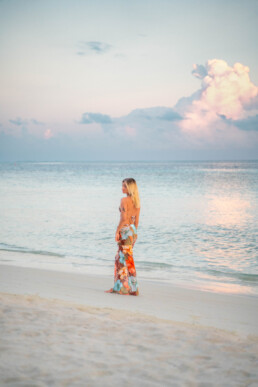 Model walking on the beach in the Maldives at sunrise