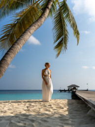 Model near palm tree on tropical island