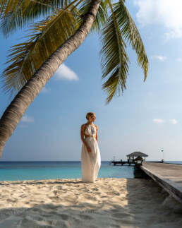 Model near palm tree on tropical island