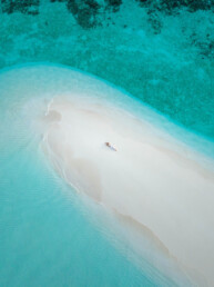 Model relaxing on sea bank over water in Maldives