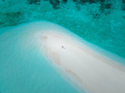 Model relaxing on sea bank over water in Maldives
